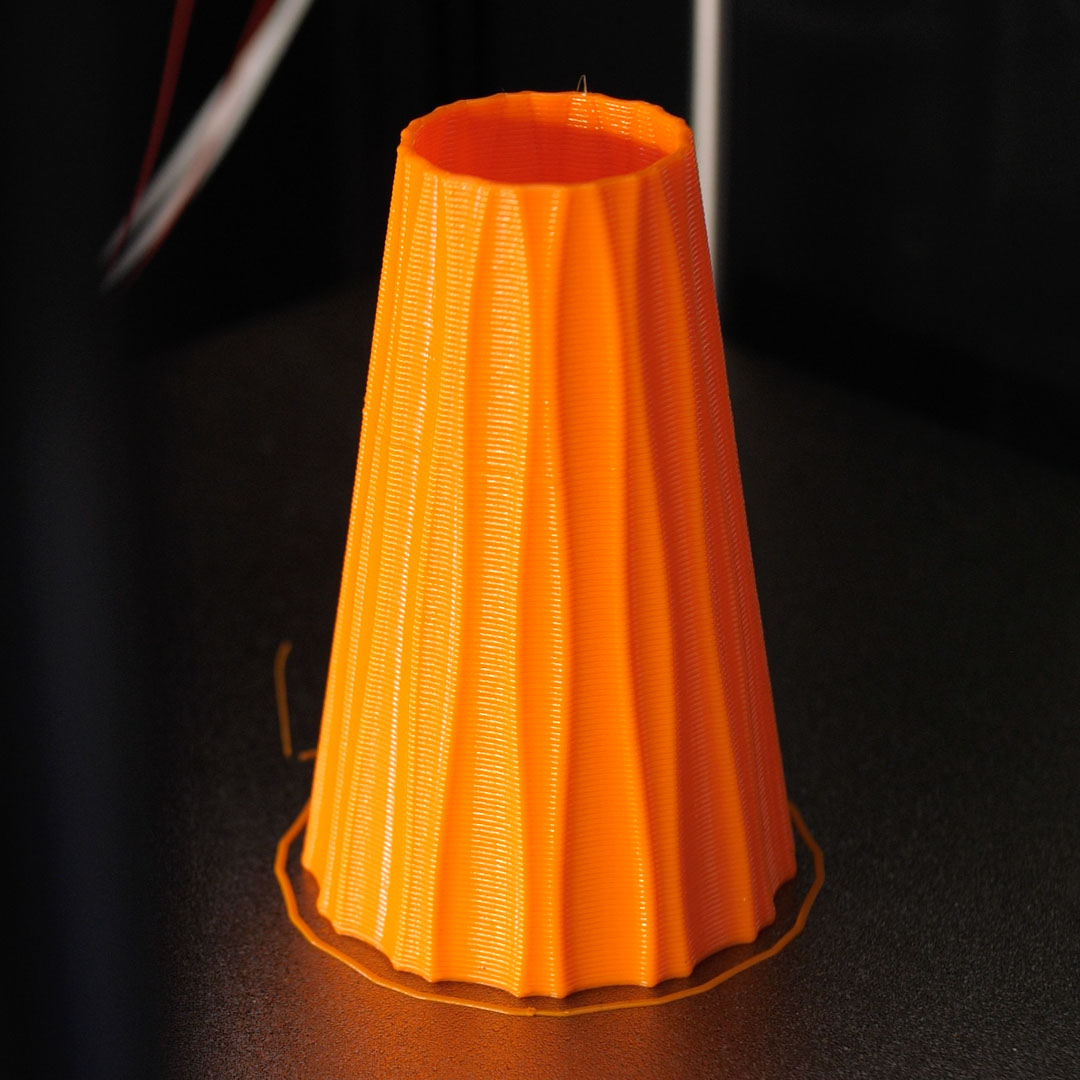 an orange nozzle-shaped vase