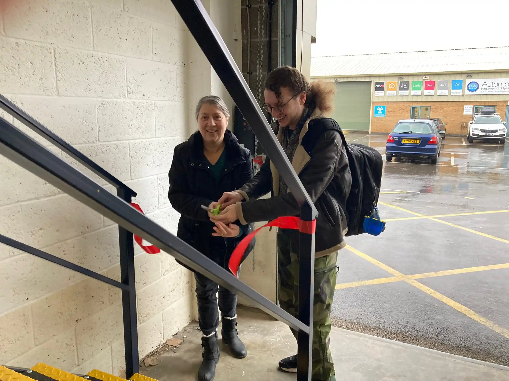Jacob and Therese cutting a red ribbon opening the factory